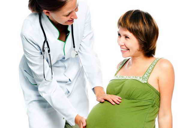 беременная и врач смотрят друг на друга и улыбаются